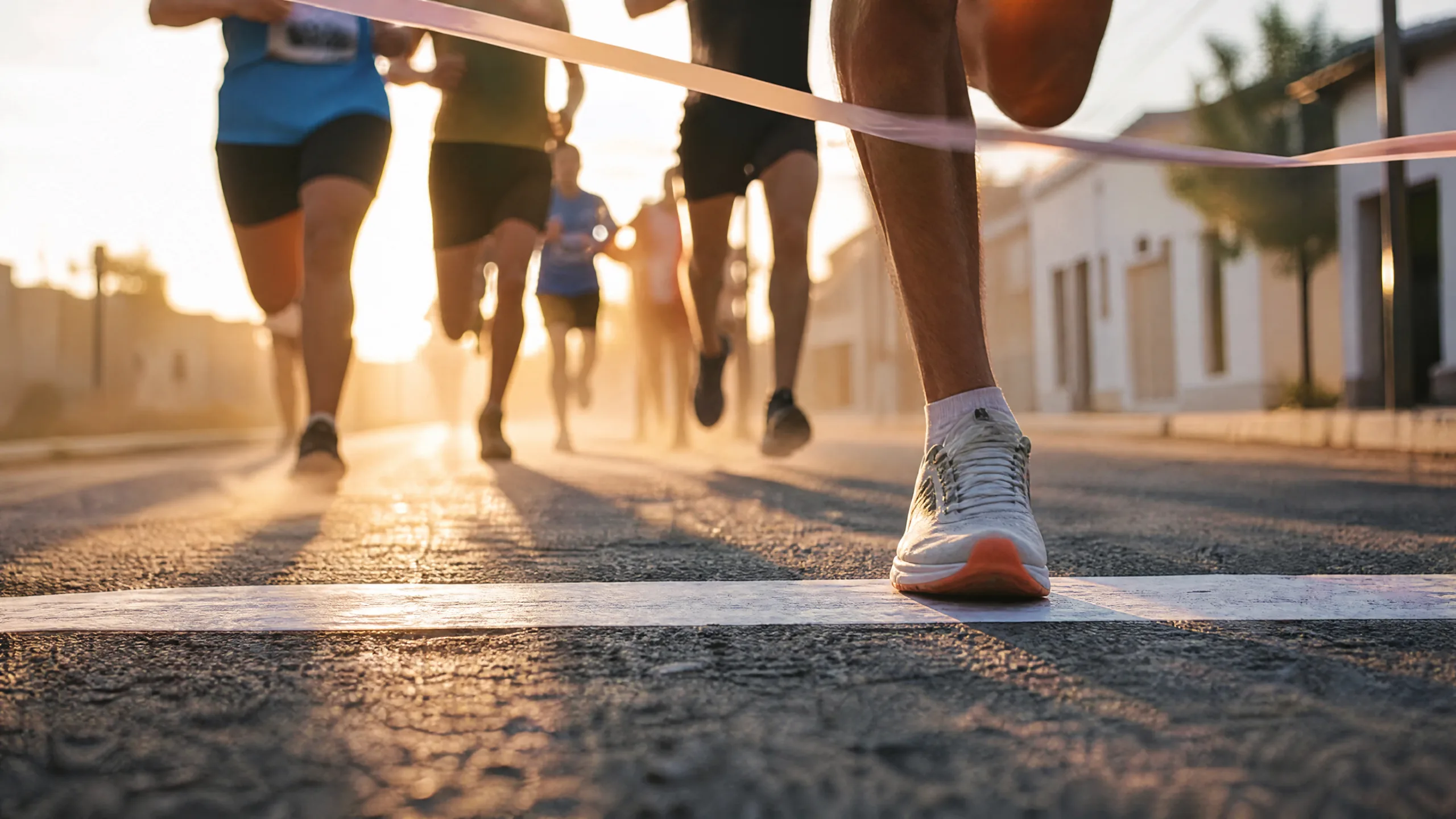 Corredores cruzando la línea de meta de una carrera al amanecer